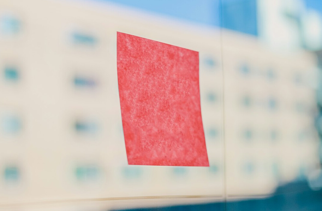Colorful sticky notes arranged on a glass wall in an office